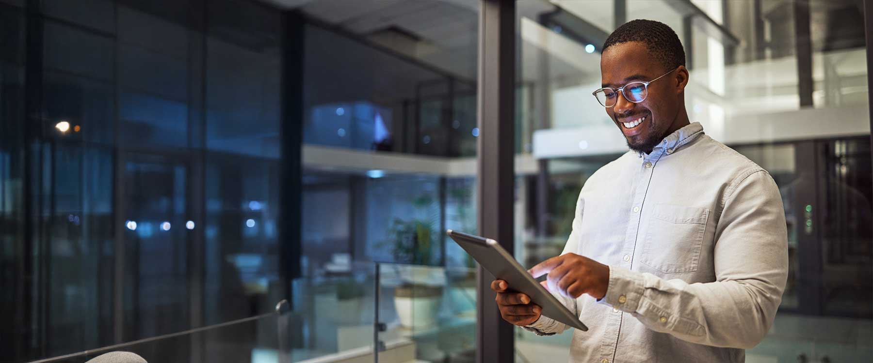 Person reviewing a tablet by a glass wall